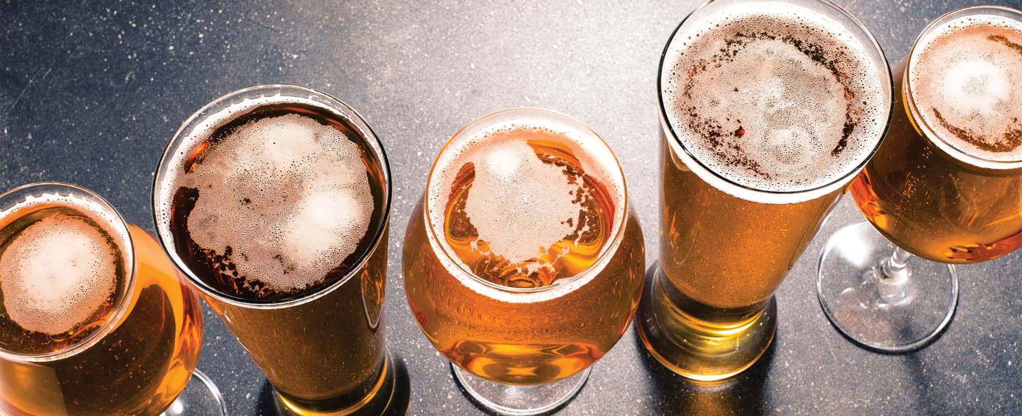 Five glasses of beer shown from above.