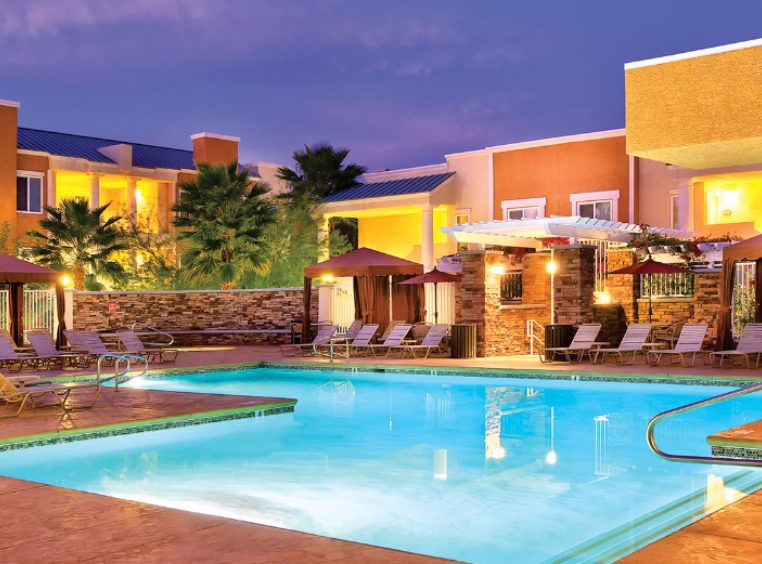 The outdoor pool of WorldMark Tropicana surrounded by sun loungers and cabanas.