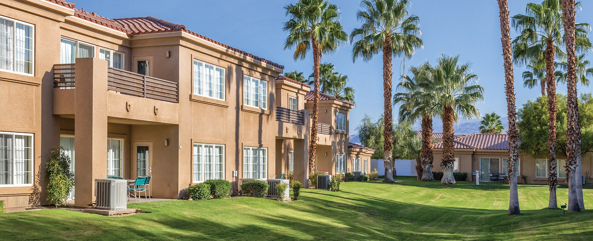 Palm trees surround the exterior of WorldMark Cathedral City, a timeshare resort in California.