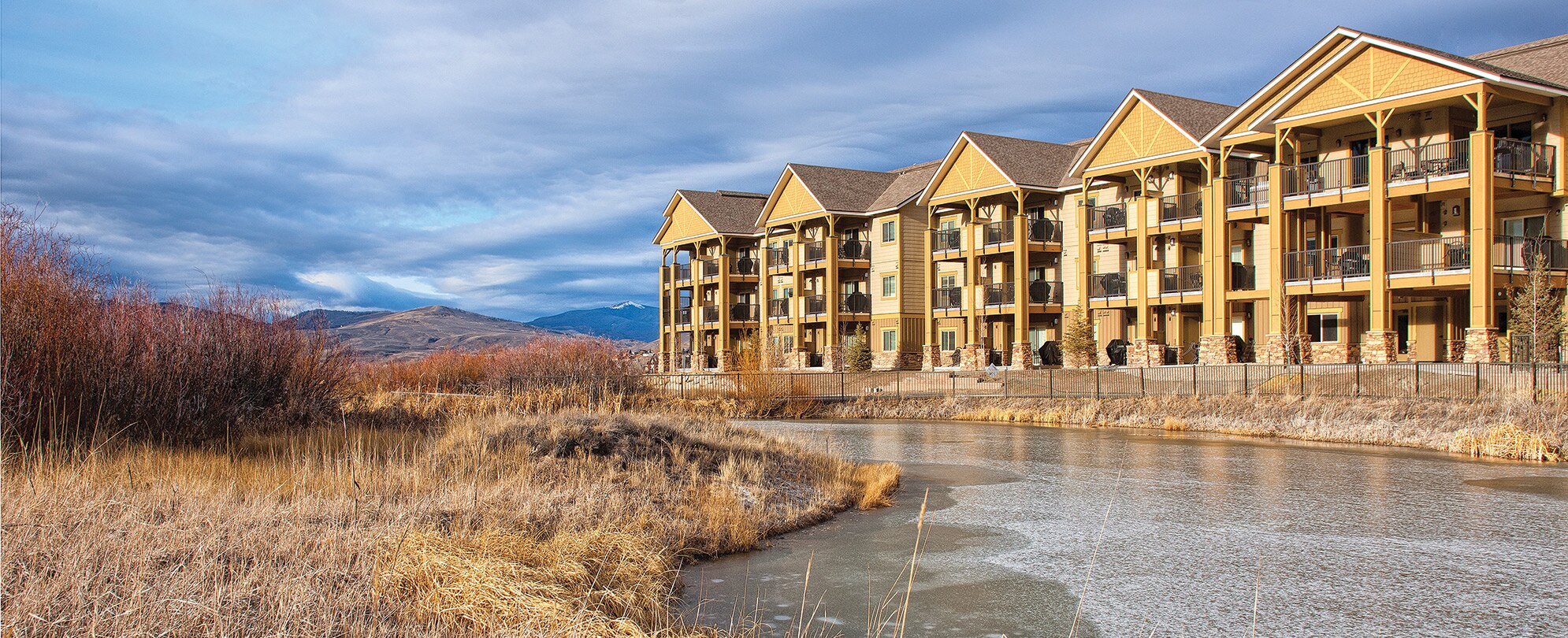 The exterior of WorldMark Rocky Mountain Preserve, a timeshare resort in Granby, Colorado, surrounded by mountains and water.